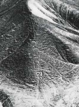 a geoglyph of a man with a hat carved on the sloping edge of a large hill range