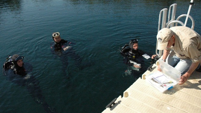 an image a dive team giving a plastic box containing artifacts that date back 10,000 years to John Gifford, an underwater archaeologist at the University of Miami, which is also a clickable link directly to the Tampa Bay Online story