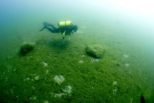 An image of underwater archeologist Mark Holley investigating a circle of stones on the Grand Traverse Bay floor, Lake Michigan, which is also a clickable link to the Chicago Tribune story
