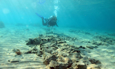 an image showing a diver exploring the sunken settlement beneath the waters off southern Greece, which is also a clickable link direct to The Guardian story
