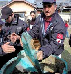 An image of Turkish salvagers remove the lid from the ship's cooking pot This image is also a clickable link direct to the Asahi Shimbun story